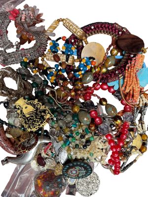 une pile de bijoux assortis sur une surface blanche
