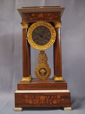 une horloge posée sur un support sur une table