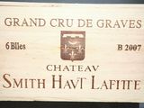 une caisse en bois sur laquelle est accrochée une pancarte indiquant « Château Smith Hav Laffite »