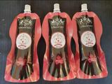 three bottles of liquid sitting on top of each other on a table