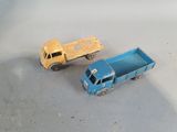 two toy trucks sitting next to each other on a table