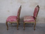 pair of pink upholstered chairs in front of a white wall