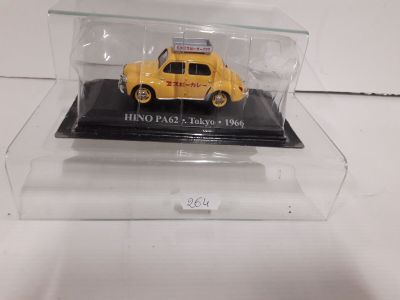 the yellow car is in a clear display case on a white surface
