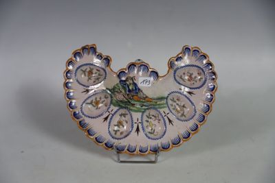 une petite assiette ornée d'un oiseau, posée sur un socle