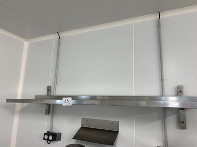 a stainless steel shelf above a stove in a kitchen