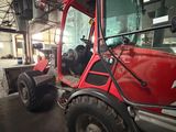 a red tractor that is parked inside of a building