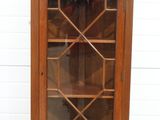 an old wooden display cabinet with glass doors on top of it