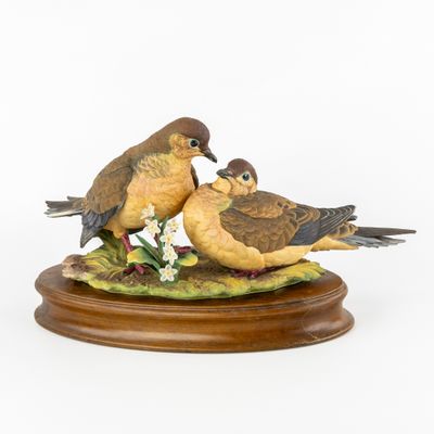 deux oiseaux perchés sur un socle en bois