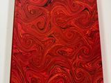 a close up of a red book with a swirl pattern on it