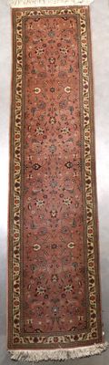 Le tapis qui recouvre le sol est rouge et beige, avec une bordure dorée.
