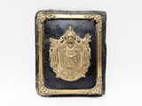 une image représentant une plaque noire et dorée ornée d'un emblème doré
