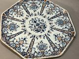 une assiette bleue et blanche posée par terre