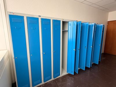 plusieurs casiers bleus sont alignés dans une pièce