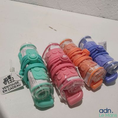 cinq ciseaux de couleurs différentes alignés sur une table