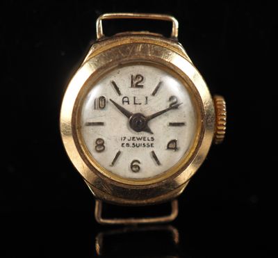 a close up of a gold wrist watch on a black surface
