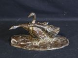 a bronze statue of a duck on a rock