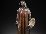 a bronze statue of a man holding a shield and a shield