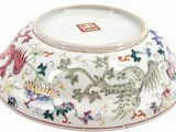 a white bowl with a dragon and flowers design on it