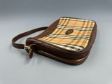 a brown and yellow plaid purse sitting on top of a table
