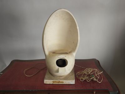 une cuvette de WC blanche posée sur un livre rouge