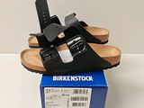 une paire de sandales noires posées sur une boîte