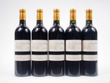quatre bouteilles de vin sont alignées sur une surface blanche