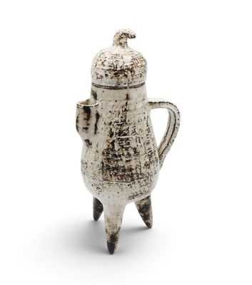 a white coffee pot with a handle on a white surface