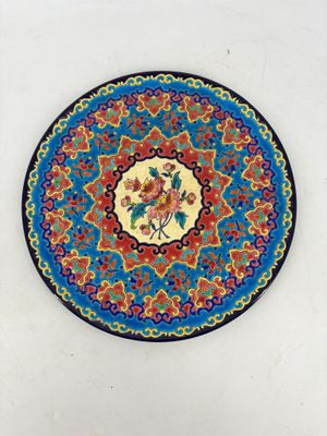 a colorful plate with flowers on it on a white surface