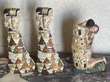 trois figurines représentant une femme et un homme, posées sur une table