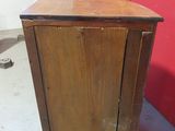 a small wooden cabinet with a door on it