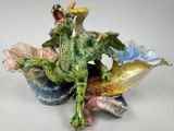 a figurine of a dragon sitting on top of a shell