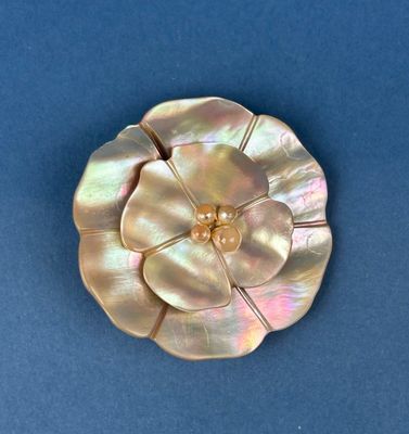 pearl flower brooch on a blue background