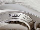 a close up of a rolex watch on a white cloth