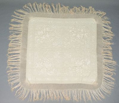 an image of a white table cloth with fringes on it