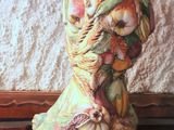 a vase sitting on top of a table next to a cloth