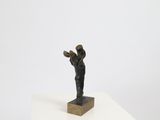 statue of a man holding a book on a white pedestal