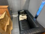 un canapé en cuir noir dans un coin de la pièce