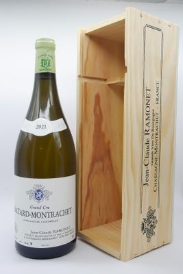 une bouteille de vin dans un coffret en bois à côté d'une bouteille de vin
