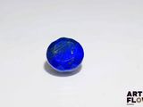 a close up of a blue stone sitting on top of a white surface