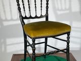 a black chair with a yellow seat sitting on a green mat
