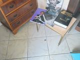 a small table with a magazine on it next to a chest of drawers
