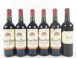 six bottles of wine are lined up in a row on a white surface