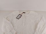 a white shirt with a tag on it sitting on top of a table