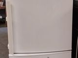 un réfrigérateur blanc posé sur une palette dans un entrepôt