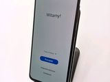 a close up of a cell phone on a stand on a white surface