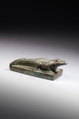 an egyptian bronze statue of a dog on a stone base