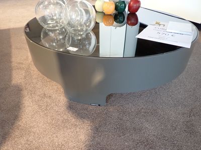 une table en verre sur laquelle sont posés des verres à vin et une bouteille