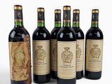 six bouteilles de vin sont alignées sur une surface blanche