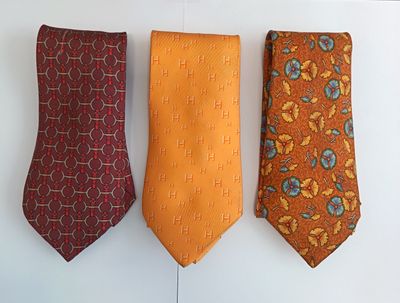 three different colored ties hanging on a wall next to each other