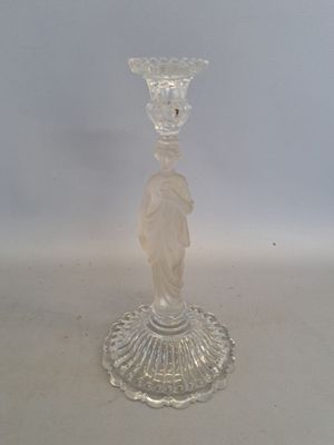 un bougeoir en verre transparent orné d'une statuette